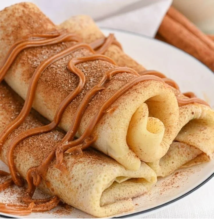 Delicious cinnamon roll protein crepes topped with icing and cinnamon.