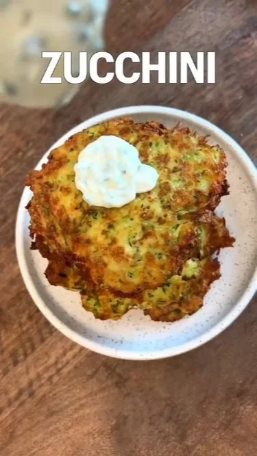 Crispy zucchini pancake topped with herbs and served on a plate