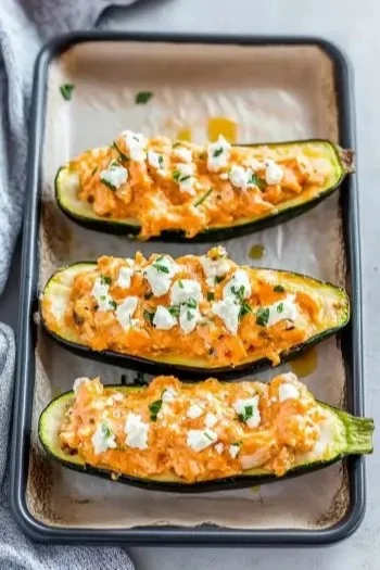 High protein buffalo chicken stuffed zucchini boats served on a plate