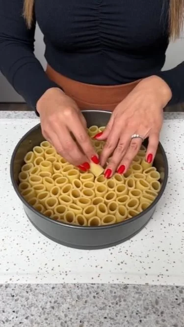 Plate of rigatoni pasta with tomato sauce and basil garnish
